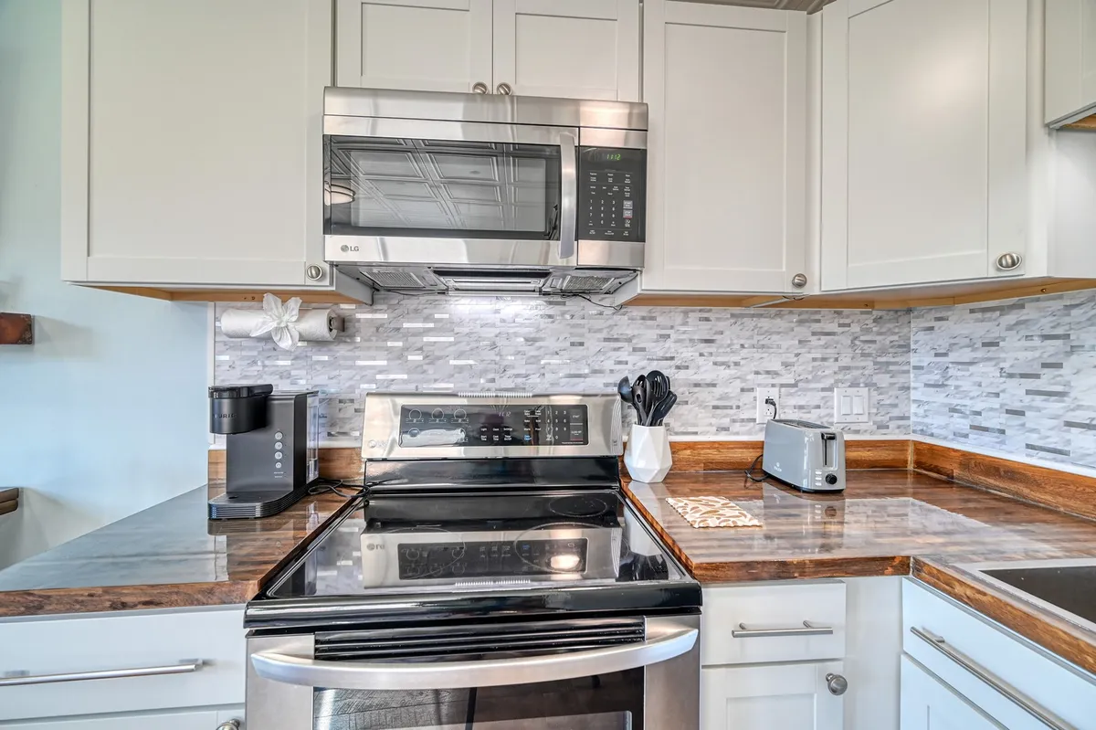 A functional and inviting kitchen with stainless steel appliances—including a stove, microwave, and coffee maker—plus a kitchen countertop ideal for meal prep or casual breakfasts.
